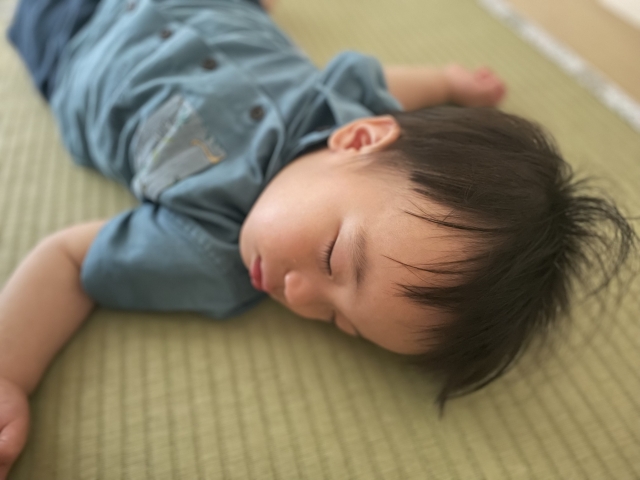 畳の上で眠っている小さな子ども